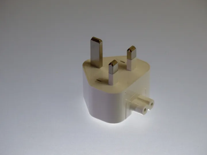 A white laptop-charger plug head with three BS 1363 pins
