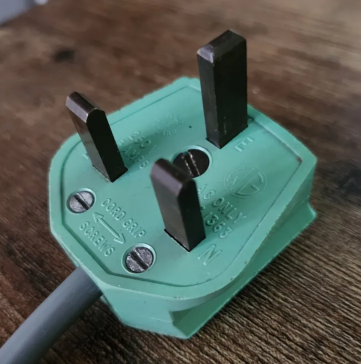 An older BS 1363 plug with unsleeved metal pins